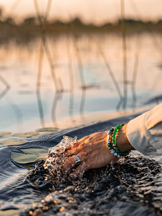 our story | dipping your hand in water on a boat safari in Africa